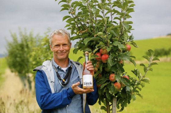 Roger Howison, one of the Integrating Tree Network hosts, holding a bottle of cider