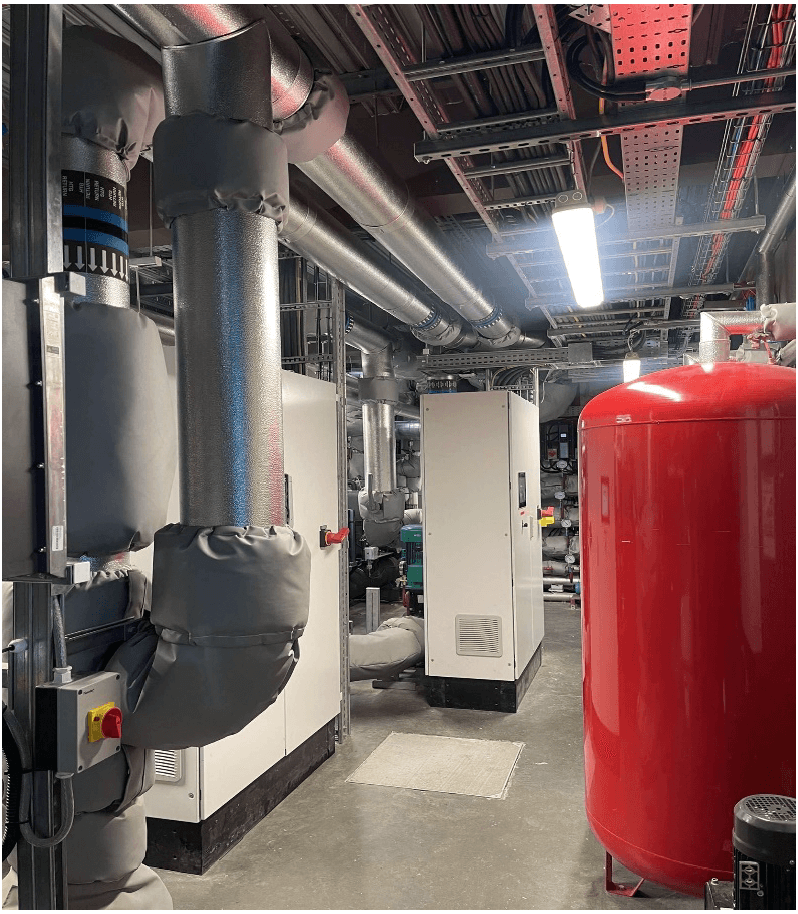 A room with heat pumps and water storage tanks.