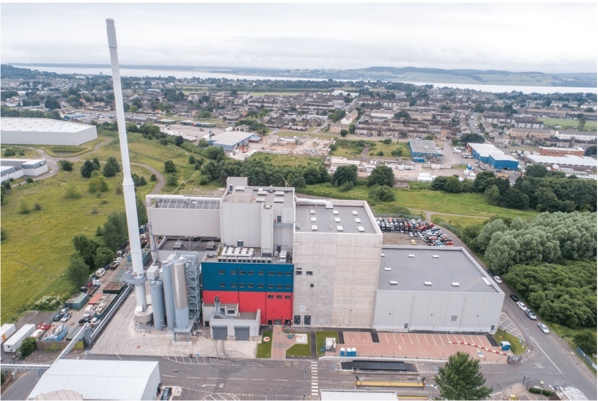 Aerial view of the Baldovie Energy from Waste facility buildings with a tall tower to the left hand side of the image.