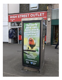 Example of a phone kiosk poster showing a bird on edge of a branch holding a bag.