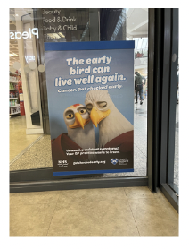 Example a campaign poster in a pharmacy window. Poster is of two birds close together.