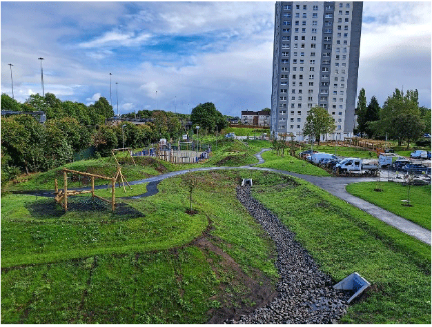 A park with a large building in the background.