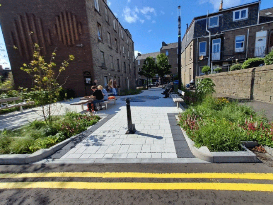 A group of people sitting on a bench in a courtyard