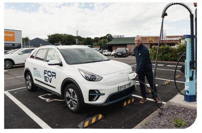 Case study: A person using an electric vehicle charging point in a shop car park