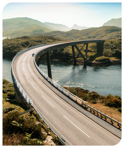 Two people walking across Kylesku Bridge in the sunshine